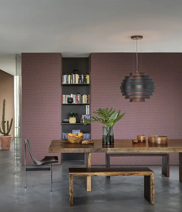 Design-Essbereich mit massivem Holztisch und rosa strukturierter Feature-Wand auf Mallorca