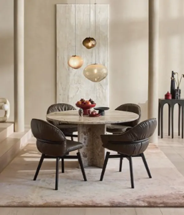 Luxurioeses Esszimmer mit rundem Marmortisch, Designer-Lederstuehlen und Pendelleuchten auf Mallorca